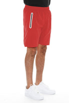 WEIV men's red running shorts with zip pocket shown from side view with white sneakers