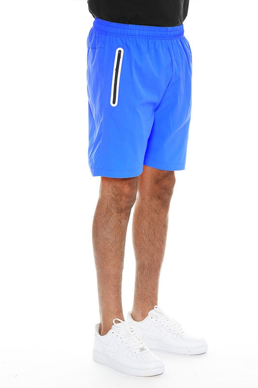 WEIV men's running shorts with zip pocket in bright blue paired with white sneakers