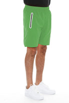 WEIV men's running shorts with zip pocket in green worn with white sneakers