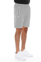 WEIV men's running shorts with zip pocket in light gray worn with white sneakers