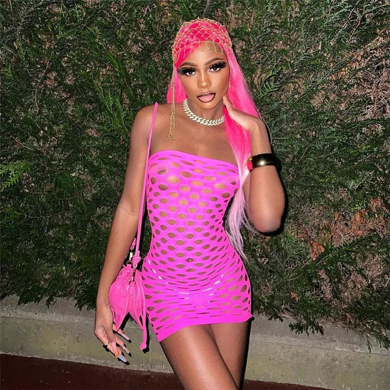 Woman wearing a bright pink see through mesh club dress with matching accessories posing outdoors
