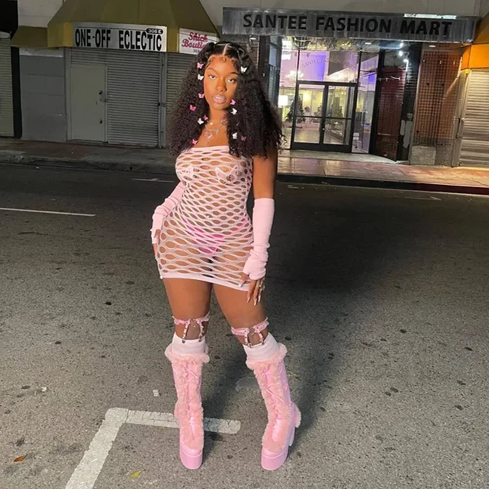 Woman wearing a pink see through mesh club dress with matching gloves and high platform boots
