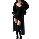 Woman wearing a sexy black club dress for women with lace trim paired with thigh-high socks and a long black cardigan