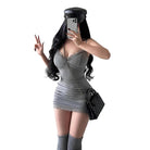 Woman wearing a sexy black club dress for women with long black hair and black cap posing against a gray wall