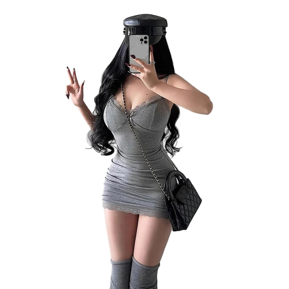 Woman wearing a sexy black club dress for women with long black hair and black cap posing against a gray wall