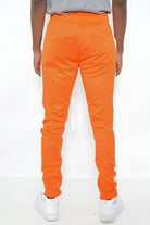 Back view of WEIV slim fit track pants for men in vibrant orange color for stylish comfort