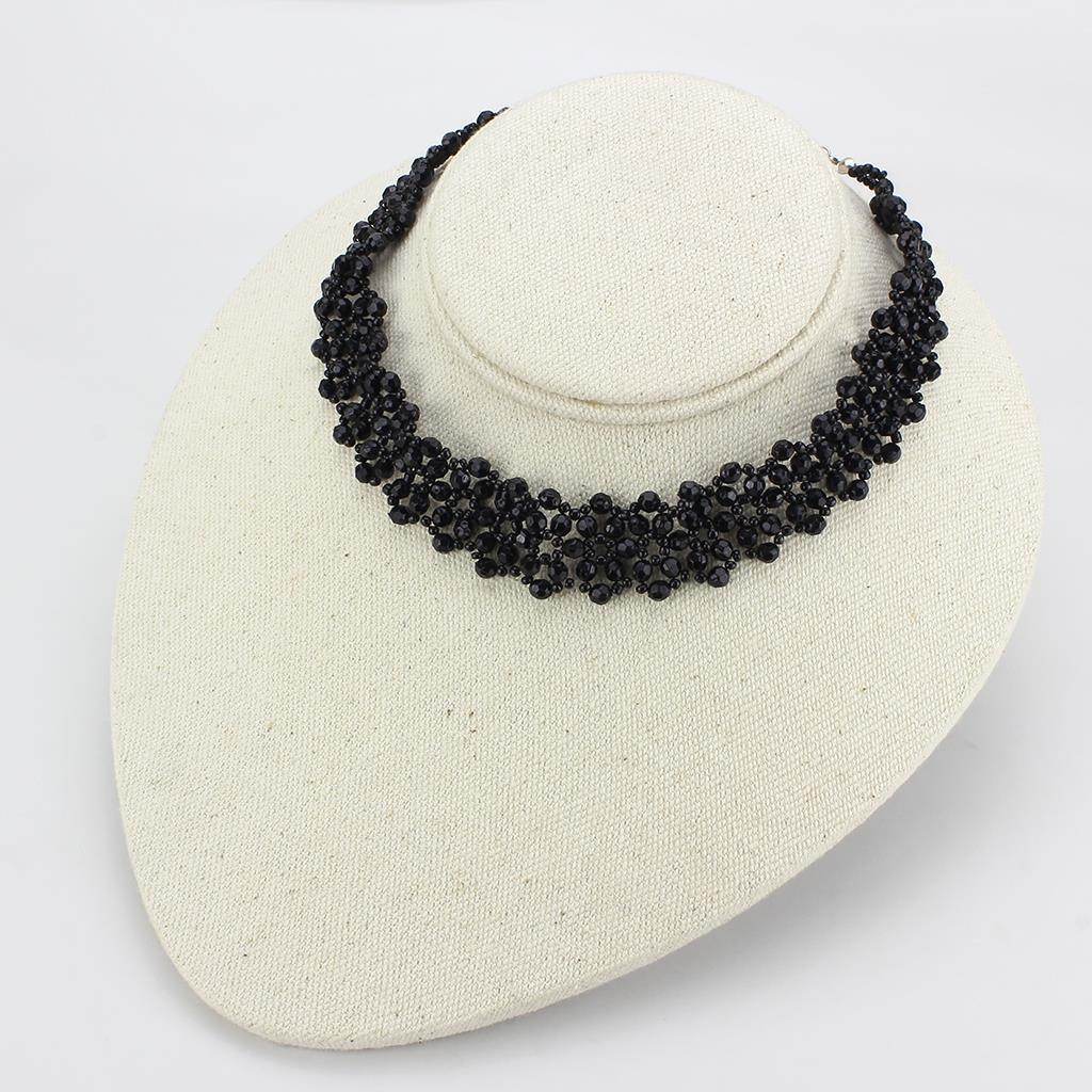 Elegant statement necklace rhodium brass featuring intricate black beading on a display bust