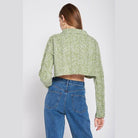 Back view of a stylish long sleeve crop shirt in green, paired with high-waisted jeans.