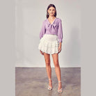 Do + Be Collection stylish long sleeve shirt in lavender paired with a white ruffled skirt