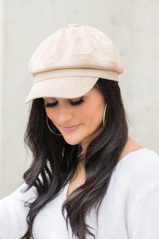 Aili's Corner stylish newsboy hat in beige worn by a woman with long dark hair and hoop earrings
