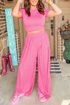 YNique stylish summer travel outfit women featuring pink crop top and wide leg pants with matching sandals