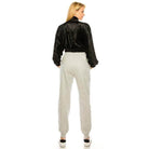 Back view of a stylish travel jacket for women in black velvet with a cinched waist