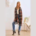 Stylish winter scarf for vacations, featuring a plaid pattern and fringed edges, worn by a model