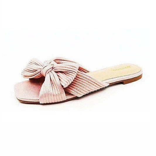 Stylish pink summer sandals for women featuring a large bow and textured design for comfort