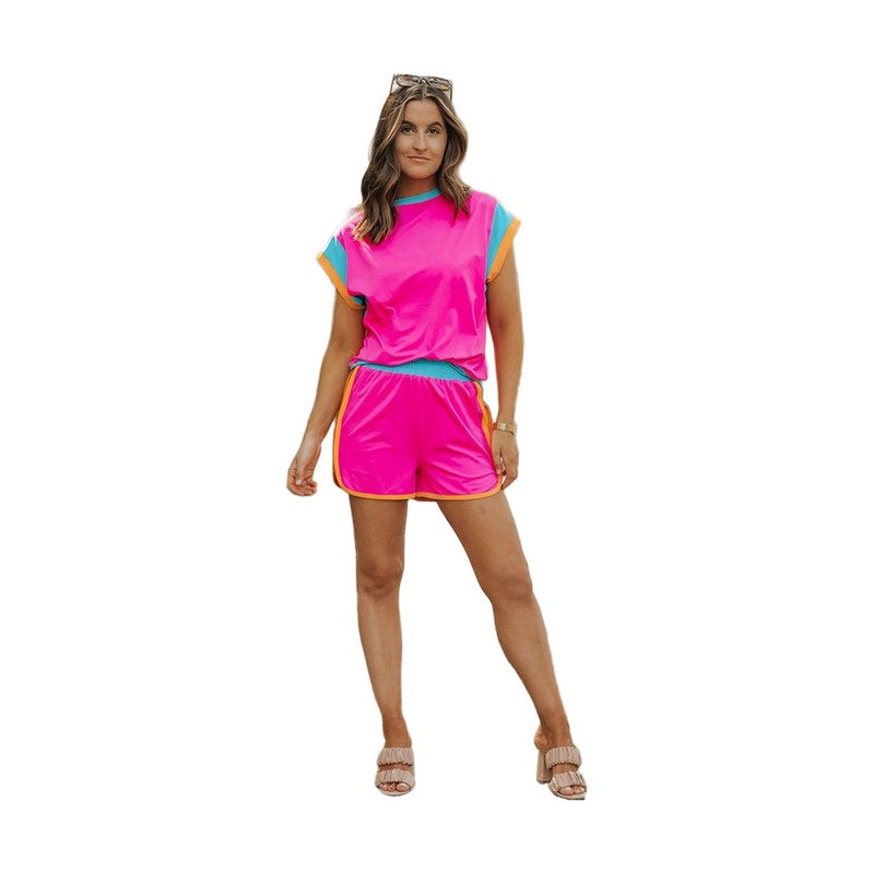 Woman wearing YNIQUE bright pink and blue summer vacation two piece outfit with shorts and sleeveless top
