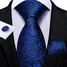 Teal blue paisley necktie elegantly paired with a black suit and matching pocket square