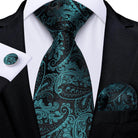 Teal blue paisley necktie paired with matching pocket square and cufflinks for formal occasions