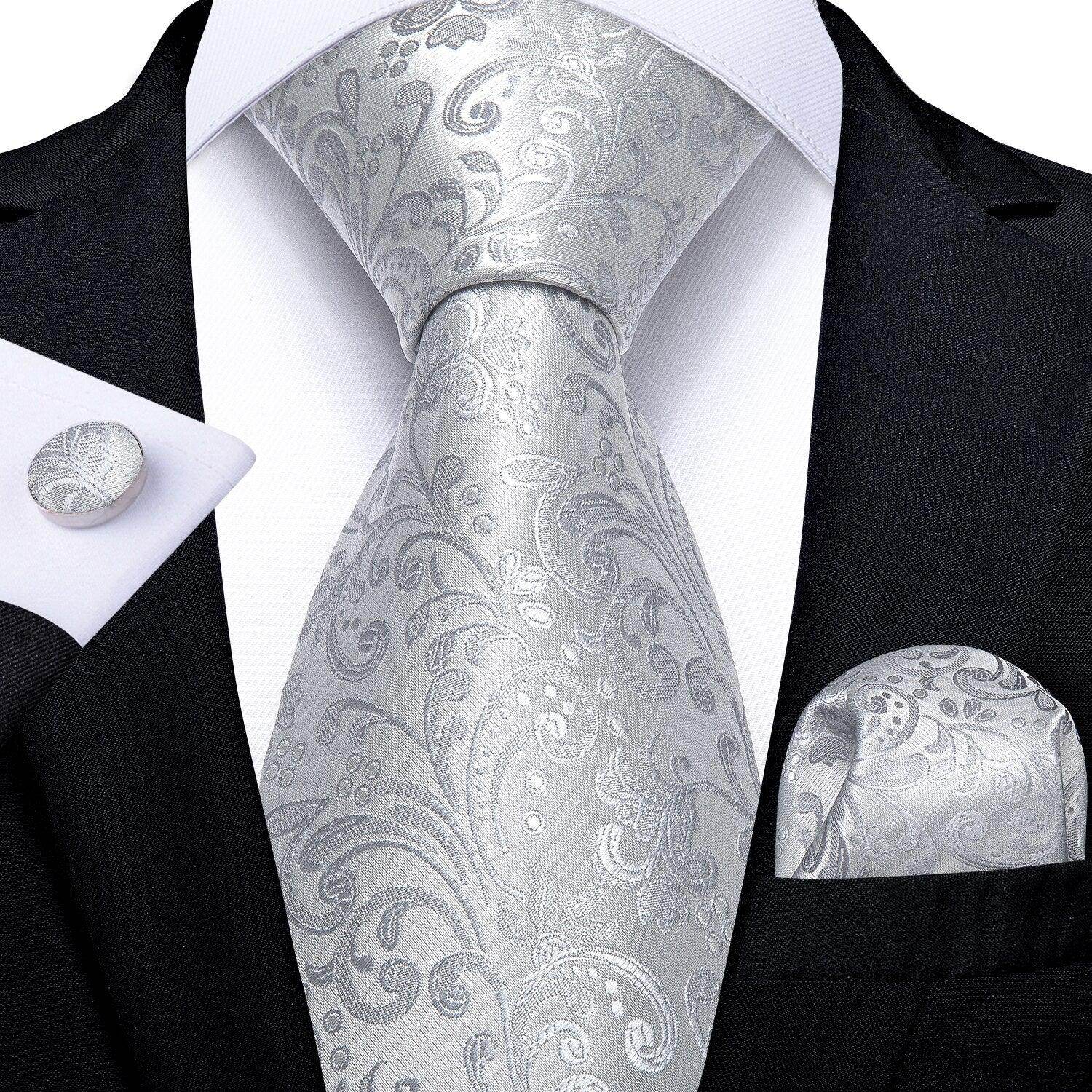 Elegant men's accessories featuring a silver tie with paisley pattern and matching pocket square