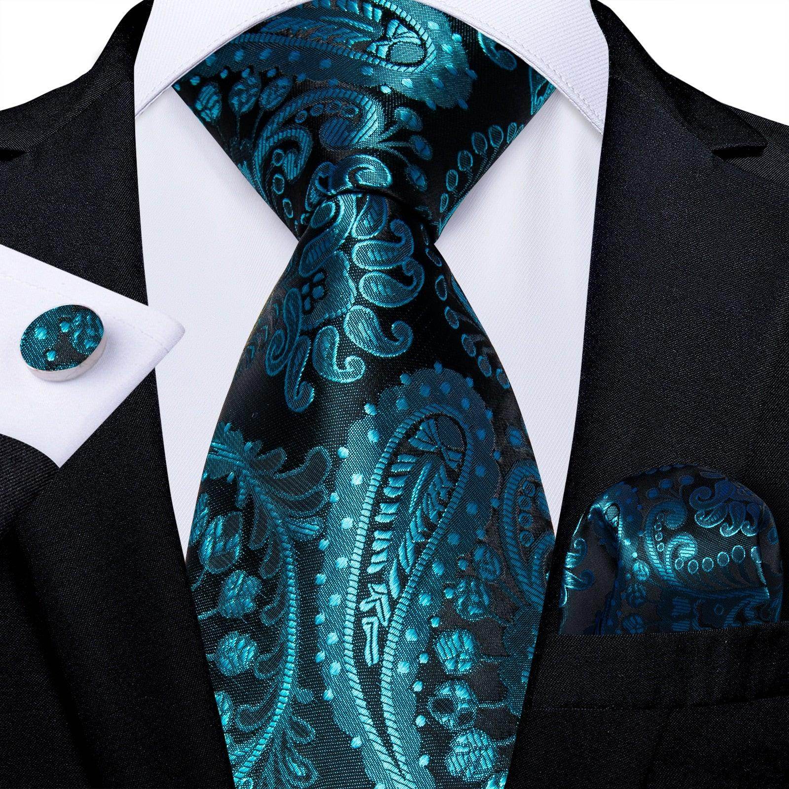 Teal blue paisley necktie elegantly styled with a matching pocket square and cufflink on a suit