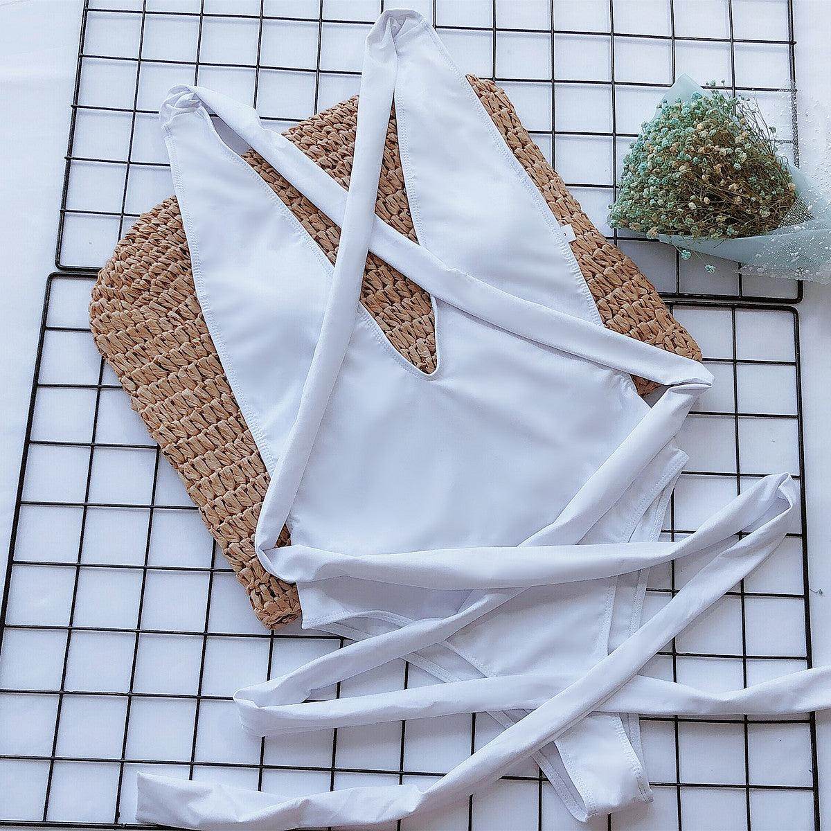 Trendsi Tied One-Piece Swimwear in White with Stylish Crisscross Straps on a Woven Mat