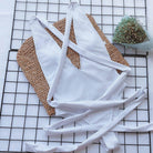 Trendsi Tied One-Piece Swimwear in White with Stylish Crisscross Straps on a Woven Mat