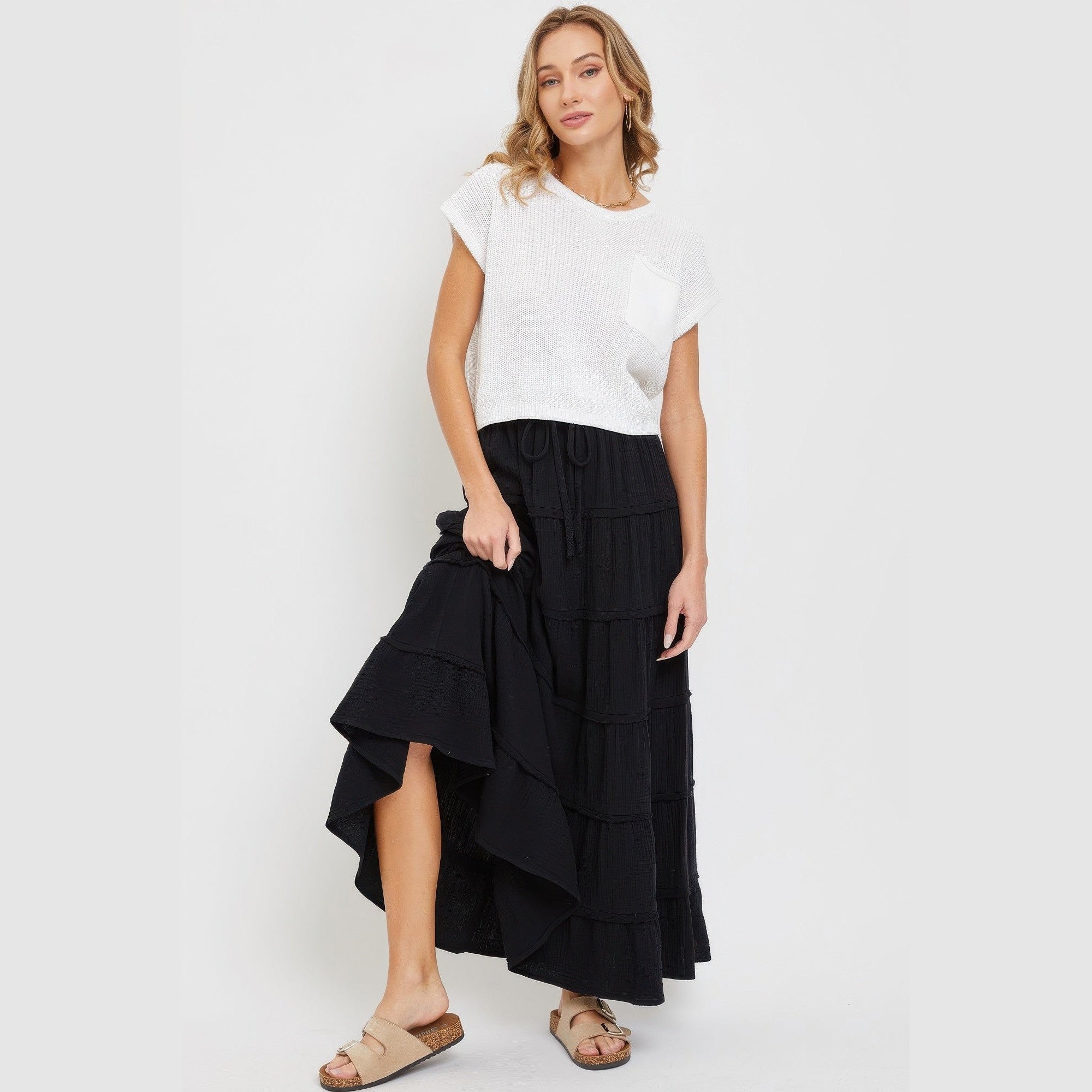 Woman wearing black tiered maxi skirt for women from VacationGrabs paired with a white short sleeve top