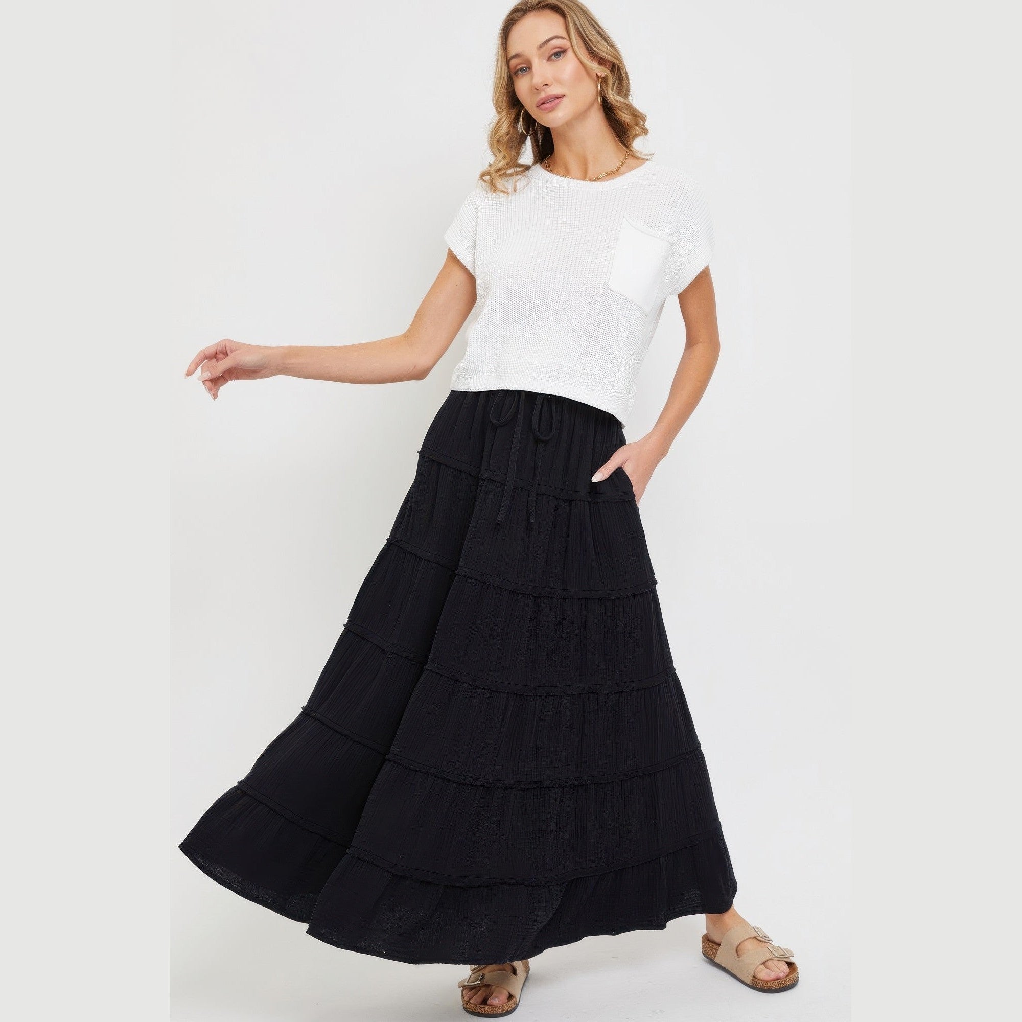 Black tiered maxi skirt for women styled with a white short sleeve top and sandals
