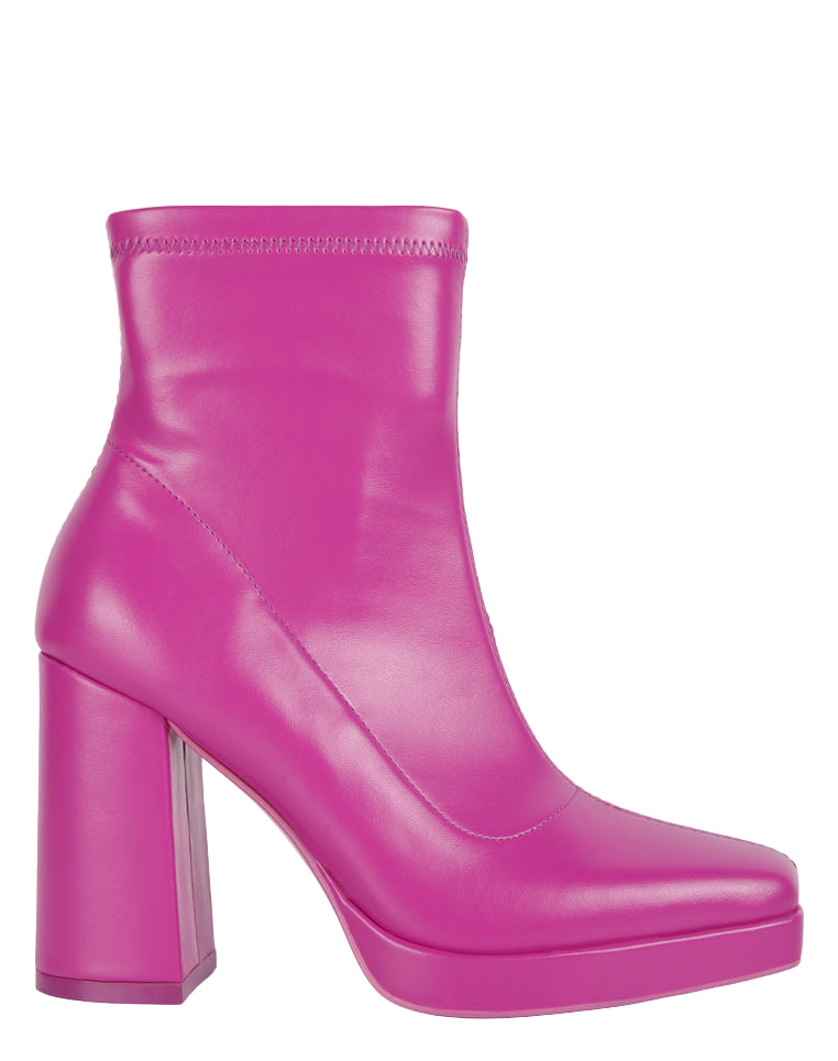 Pink rubber boot with a thick platform sole on a white background