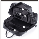 Interior view of a black VacationGrabs travel backpack for men and women with multiple compartments and pockets