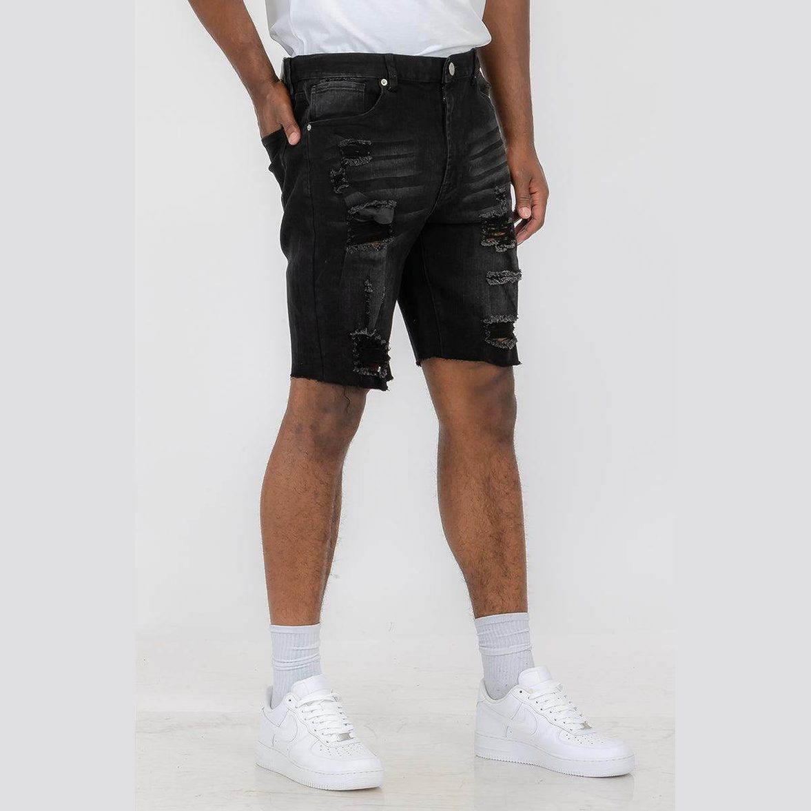 Men's ripped black denim shorts by WEIV, styled with a trendy camo shirt and shorts