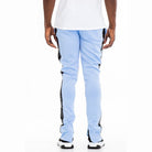 Back view of trendy leather stripe joggers in light blue with black side stripes worn by male model