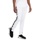 WEIV trendy leather stripe joggers in white with black leather side stripes worn with black slip-on sneakers