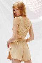 Woman wearing Miss Sparkling beige trendy retro activewear set with sleeveless crop top and high-waisted shorts
