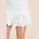 VacationGrabs white trendy summer mini skirts with ruffled hem and drawstring detail