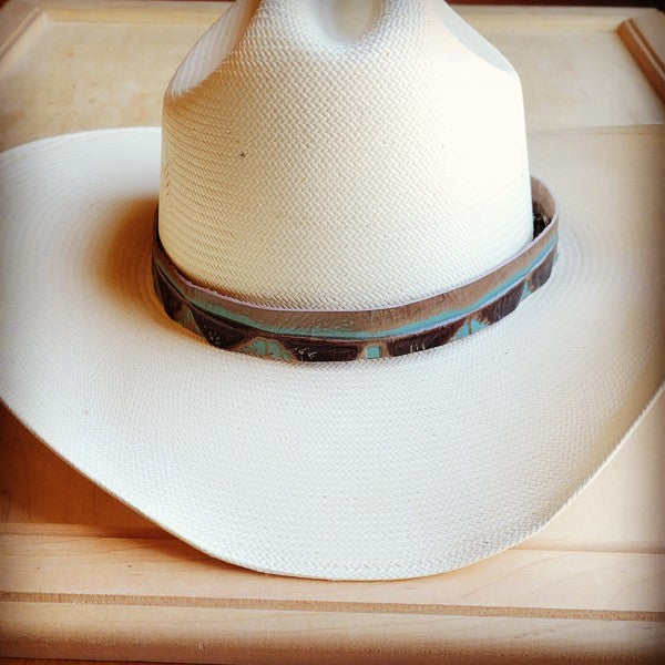 Turquoise Navajo leather hat band on a white cowboy hat, adding a stylish touch.