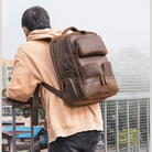 Urban leather weekender backpack worn by a man, featuring multiple pockets for travel convenience