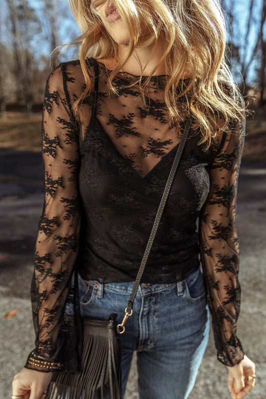 YNIQUE black lace mesh long sleeve blouse over black cami paired with blue jeans and fringe bag