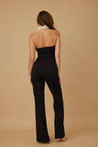 Back view of a sleek black vacation jumpsuit outfit for women, perfect for stylish summer outings