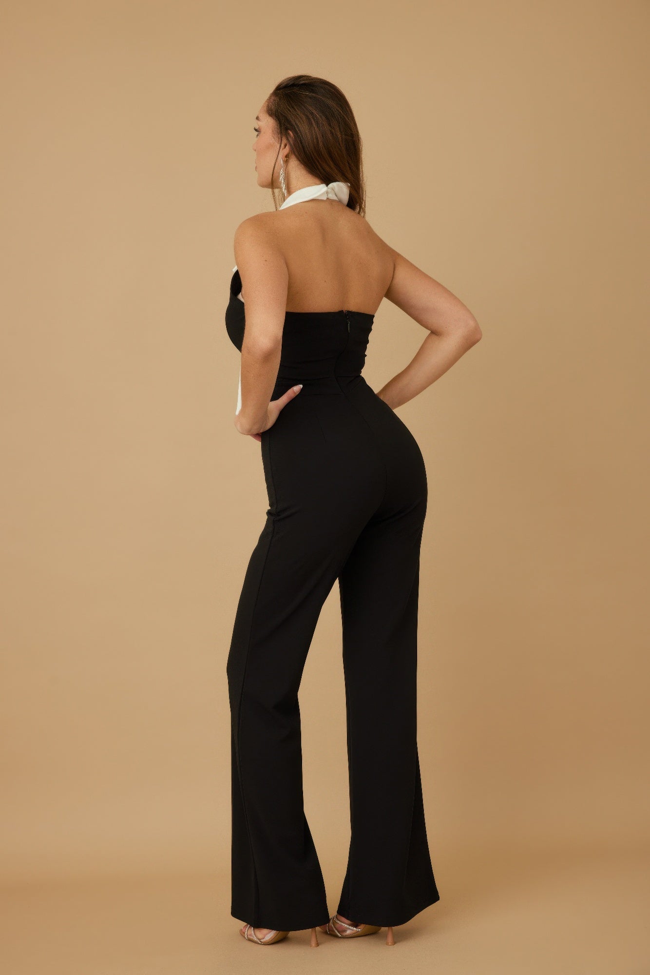 Stylish black vacation jumpsuit outfit for women with halter neck design and flared legs
