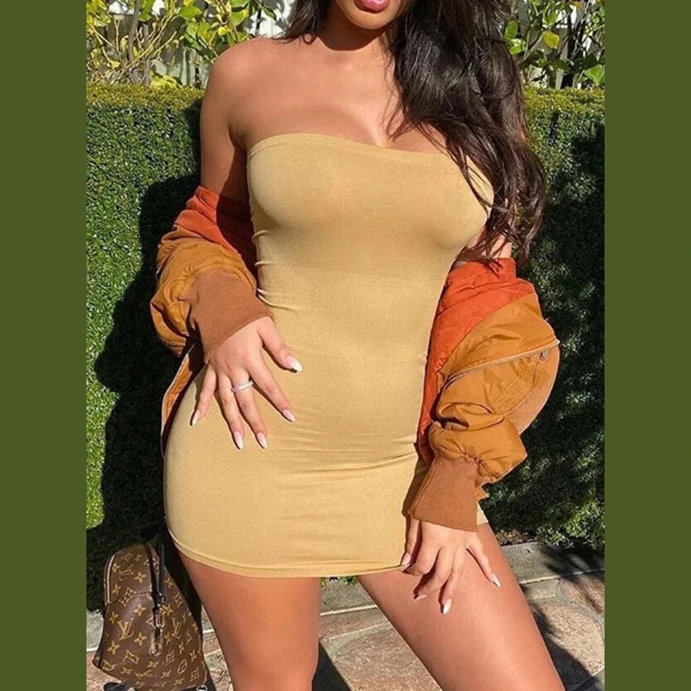 Beige backless club party dress women in strapless bodycon style worn with orange jacket outdoors