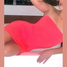 Red backless club party dress women wearing strapless fitted mini dress reclining indoors