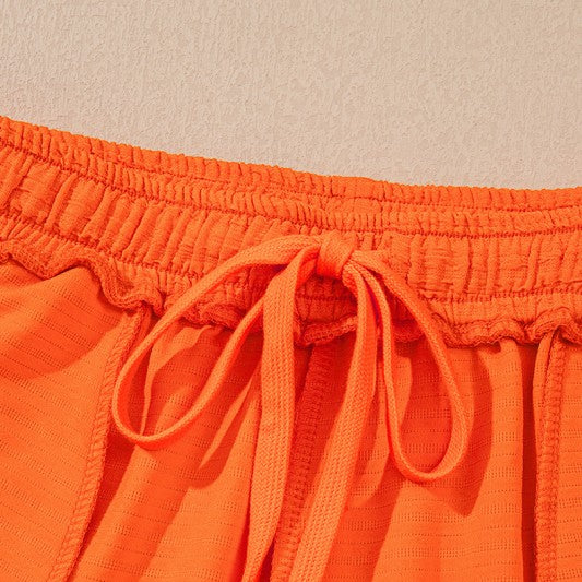 Close-up of orange drawstring waistband detail on casual vacation outfit for women by YNIQUE