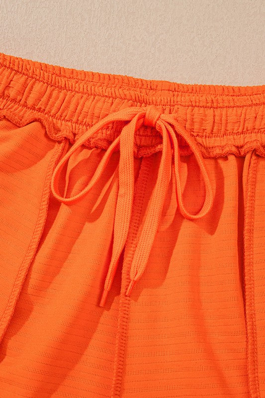 Close-up of orange drawstring waistband detail on casual vacation outfit for women by YNIQUE