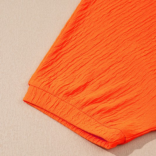 Orange textured fabric detail from YNIQUE casual vacation outfit for women with short sleeve cuff