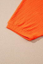 Orange textured fabric detail from YNIQUE casual vacation outfit for women with short sleeve cuff