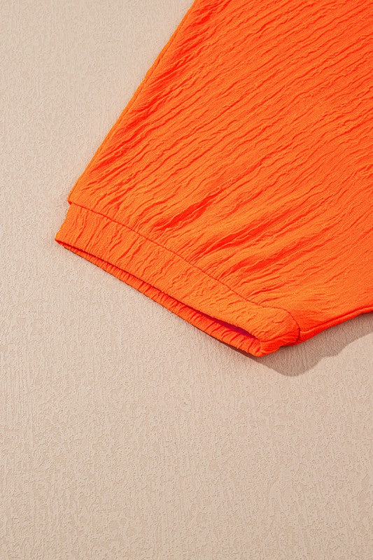 Orange textured fabric detail from YNIQUE casual vacation outfit for women with short sleeve cuff