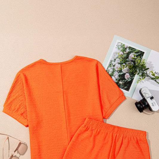 Orange two-piece casual vacation outfit for women with short sleeves and elastic waistband shorts