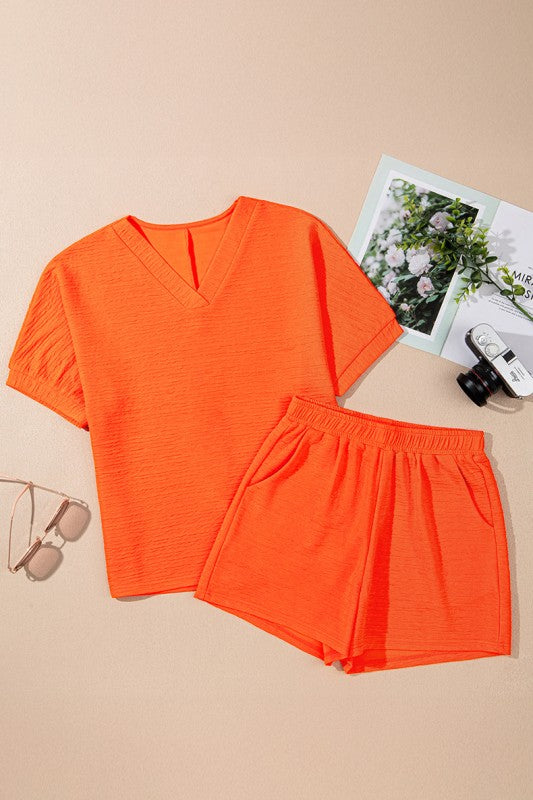 YNIQUE bright orange casual vacation outfit for women with V-neck top and elastic waist shorts