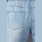 Close-up of back pocket on light wash frayed hem drawstring jean shorts by Denim Lab USA