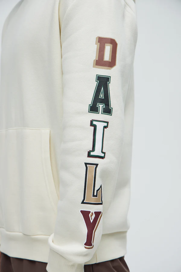 Men's cream hustle daily hoodie for vacation with colorful block letters printed on sleeve